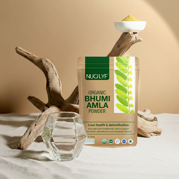 Organic Bhumi Amla powder pouch with a glass of water, wooden decor, and herbal powder bowl