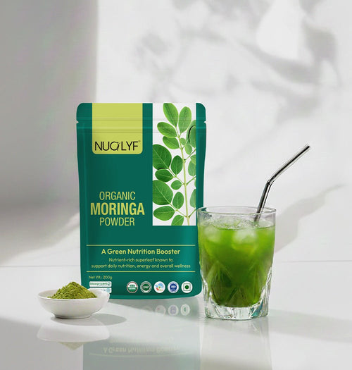 Organic moringa powder packet with a glass of green moringa drink and a spoonful of powder