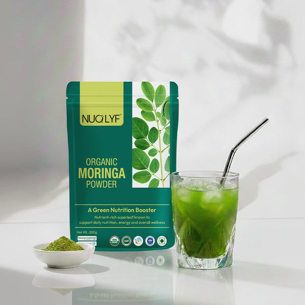 Organic moringa powder packet with a glass of green moringa drink and a spoonful of powder